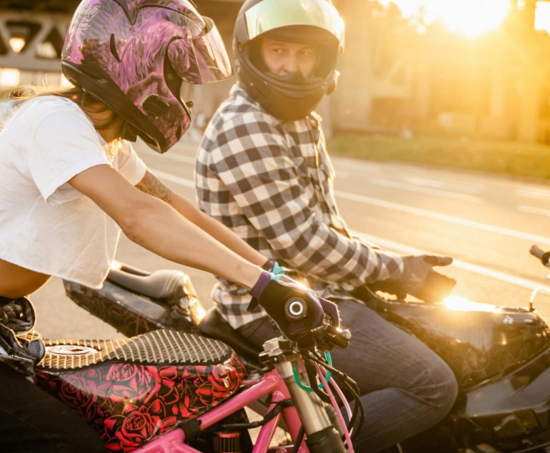 motorbike riders in city sitting on motorbikes at sunset